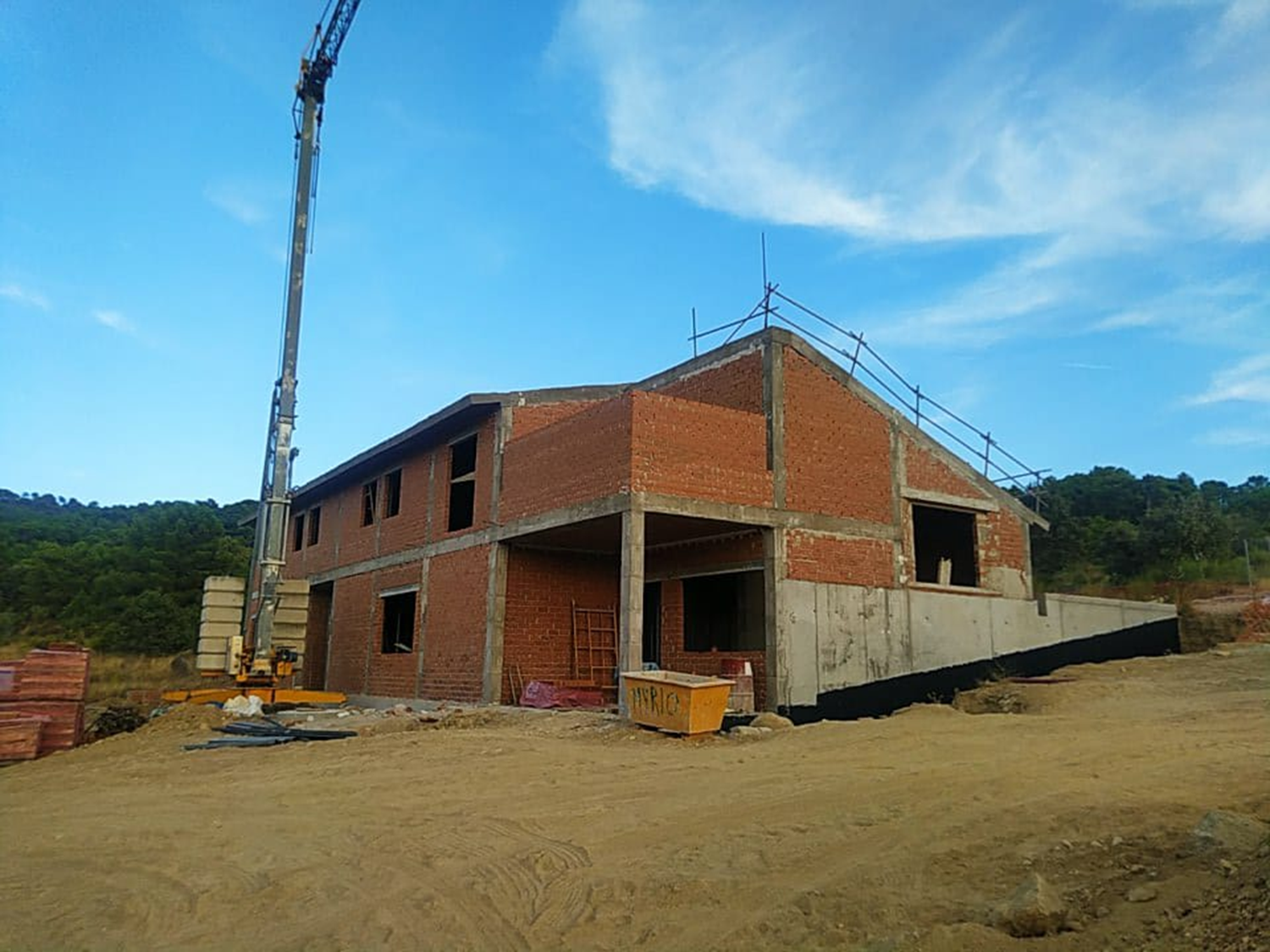 Estructura de ladrillo de la ampliación del monasterio en obras con una grúa