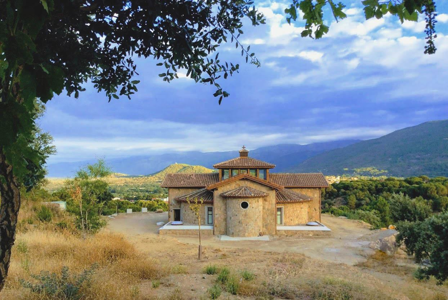 Iglesia de piedra del monasterio en construcción con la sierra al fondo